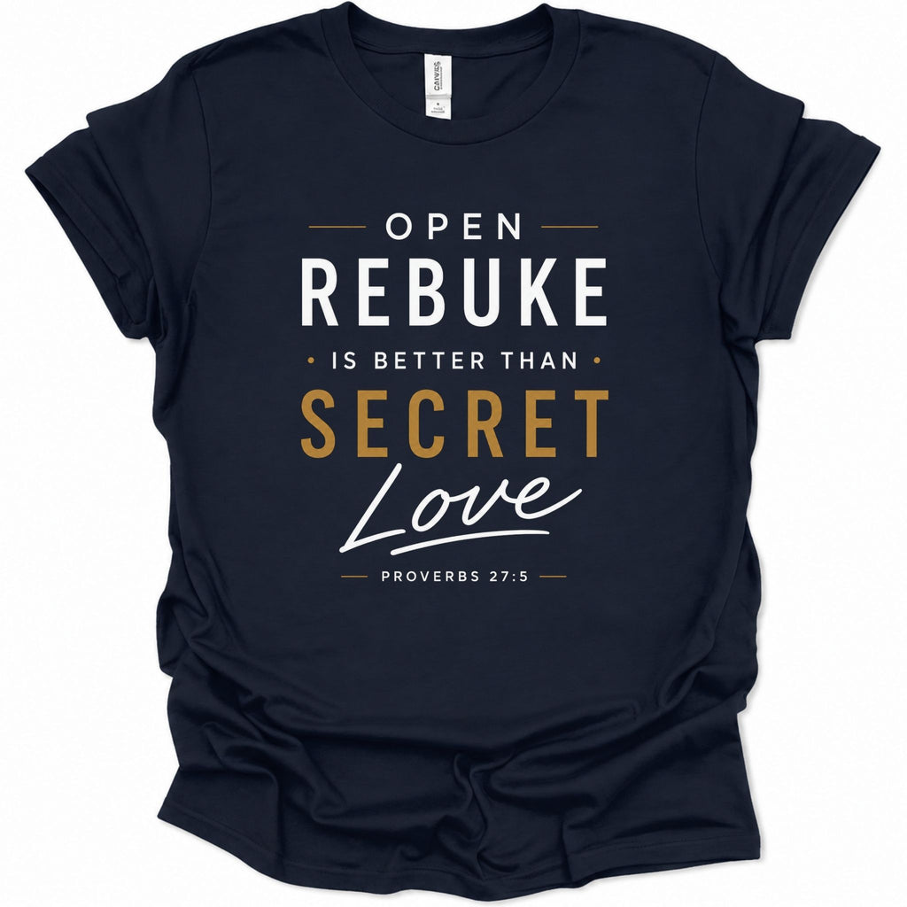 A navy blue short-sleeve t-shirt with a graphic print on the front reading 'OPEN REBUKE IS BETTER THAN SECRET Love' and 'PROVERBS 27:5' in white and gold lettering, shown on a plain white background.