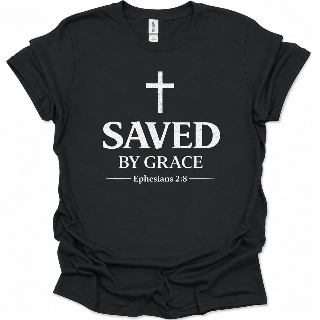 A black short-sleeve crewneck t-shirt with a distressed white graphic print on the front featuring a cross, the word 'SAVED', 'BY GRACE', and the Bible verse 'Ephesians 2:8'.