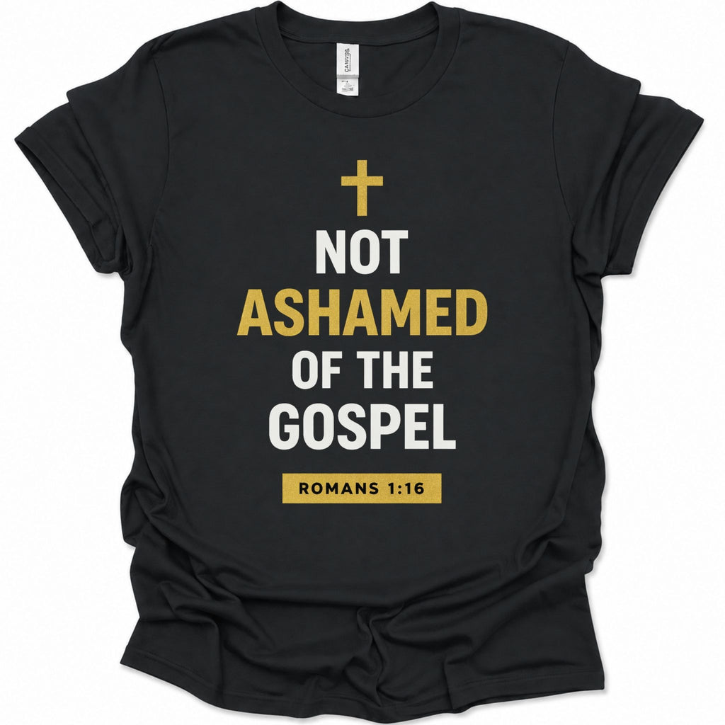 A black short-sleeve t-shirt with a graphic print on the front. The print features a gold cross above the text 'NOT ASHAMED OF THE GOSPEL' in white and gold lettering, and a gold box at the bottom reading 'ROMANS 1:16'.