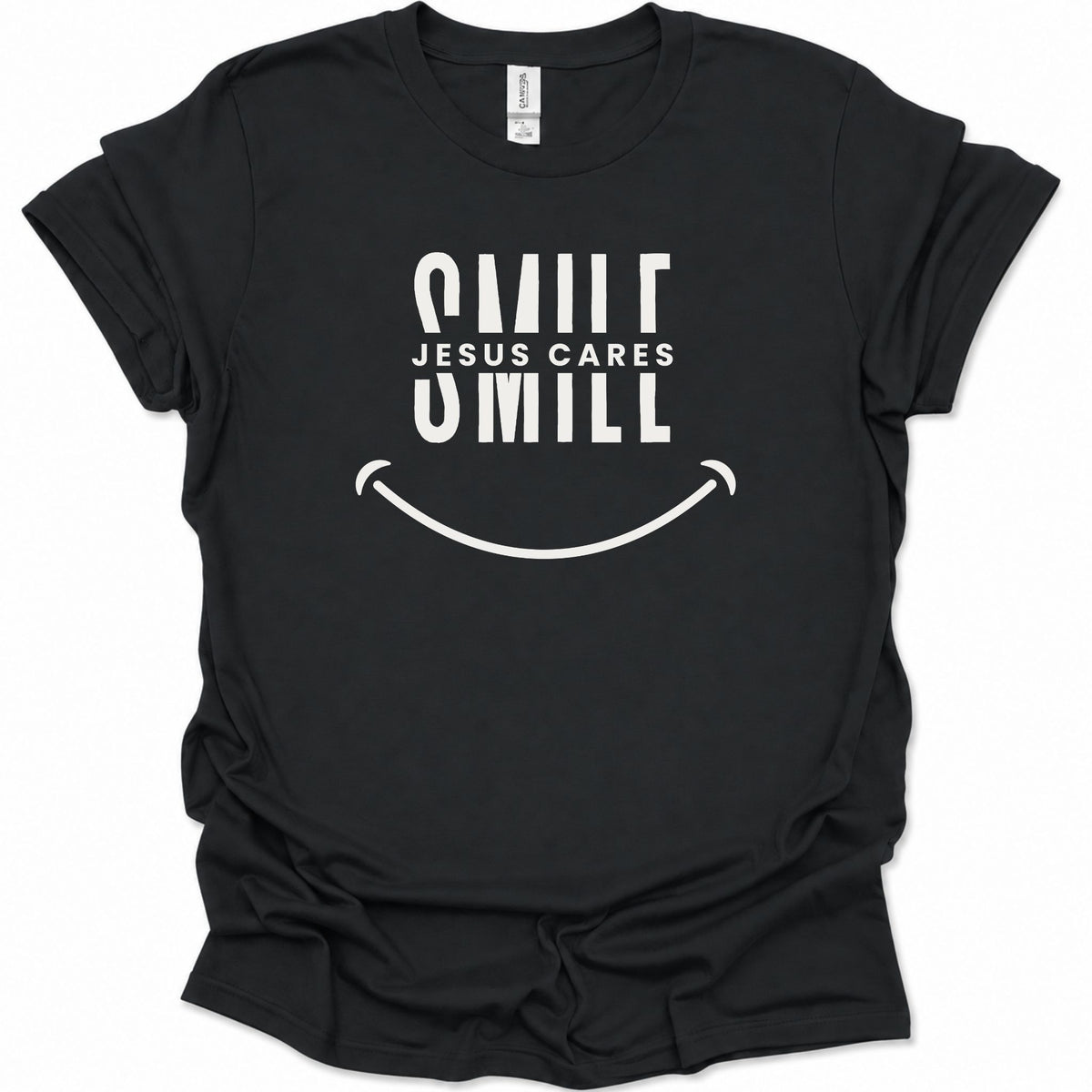A black short-sleeve t-shirt with a white graphic print that reads 'SMILE JESUS CARES SMILL' above a smiley face, shown on a plain white background.