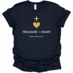 A navy blue short-sleeve t-shirt with a gold and white graphic on the chest featuring a cross, a heart, the text 'TREASURE -> HEART', and 'MATTHEW 6:21'.