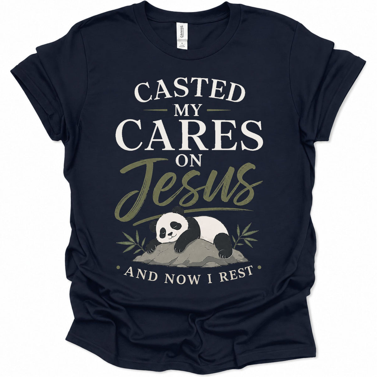 A navy blue short-sleeve t-shirt with a graphic print on the front. The print features the text 'CASTED MY CARES ON Jesus AND NOW I REST' in white and olive green lettering, along with an illustration of a sleeping panda resting on a rock with bamboo leaves.