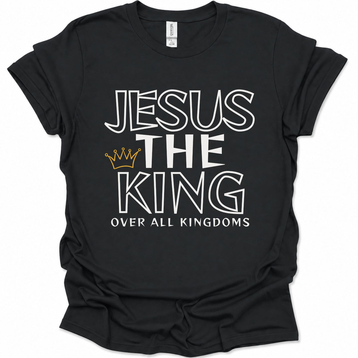 A black short-sleeve t-shirt with a graphic print reading 'JESUS THE KING OVER ALL KINGDOMS' in white outlined lettering, featuring a small gold crown icon between 'THE' and 'KING'.