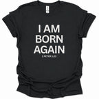A black short-sleeve t-shirt with bold white text reading 'I AM BORN AGAIN' and '1 PETER 1:23' printed on the front, shown against a plain white background.