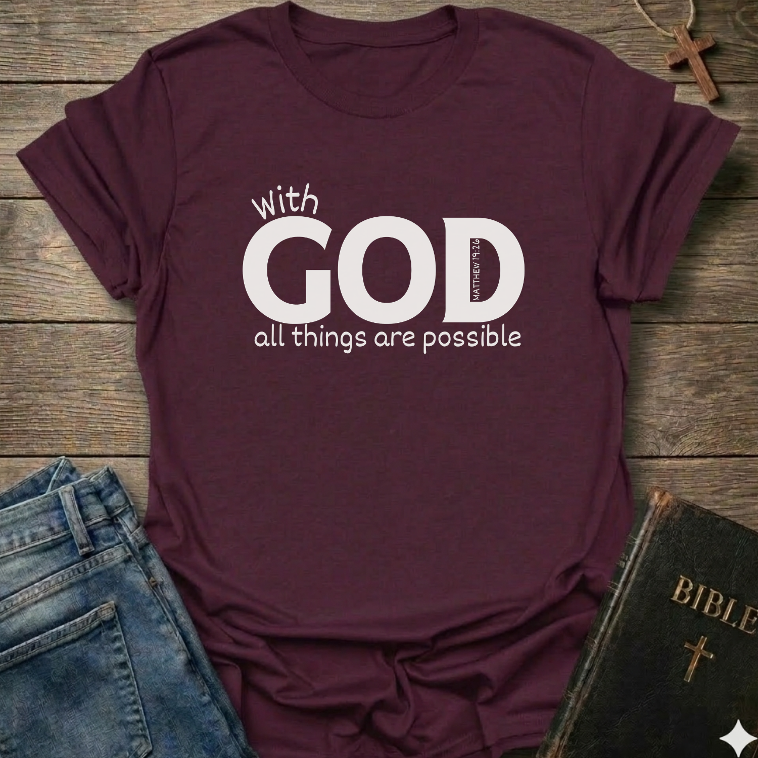 Maroon t-shirt with 'With GOD all things are possible' Matthew 19:26 bold faith apparel conversation starter
text on a wooden surface with jeans and a Bible.