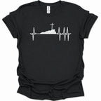 A black short-sleeve crewneck t-shirt with a white graphic print of a cross on top of a silhouette, integrated into an EKG heartbeat line, shown against a plain white background.