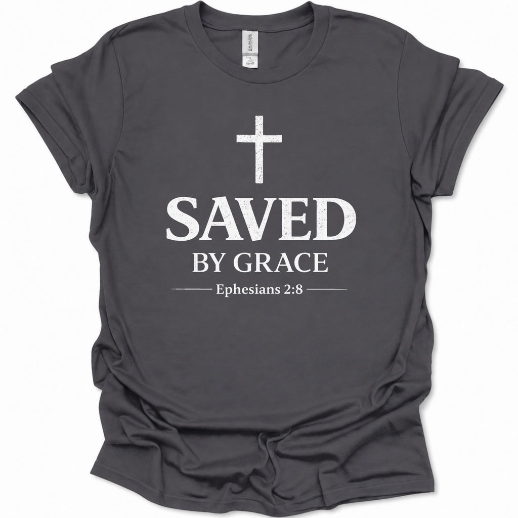 A dark heather gray short-sleeve t-shirt with a distressed white graphic print on the front featuring a cross, the words 'SAVED BY GRACE', and 'Ephesians 2:8'.