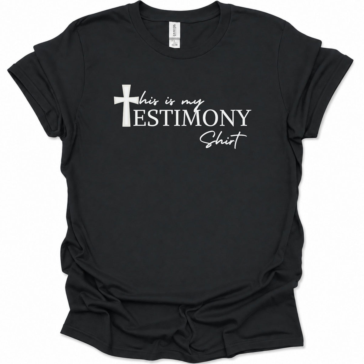 A black short-sleeve t-shirt with a white graphic print on the front that reads 'this is my TESTIMONY Shirt' alongside a Christian cross, displayed against a plain white background.