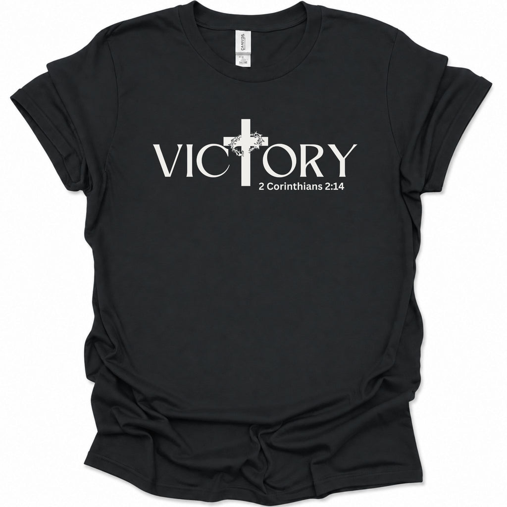 A black short-sleeve crewneck t-shirt with a white graphic print on the front. The graphic features the word 'VICTORY' in a serif font, with a Christian cross replacing the letter 'I'.