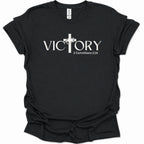A black short-sleeve crewneck t-shirt with a white graphic print on the front. The graphic features the word 'VICTORY' in a serif font, with a Christian cross replacing the letter 'I'.