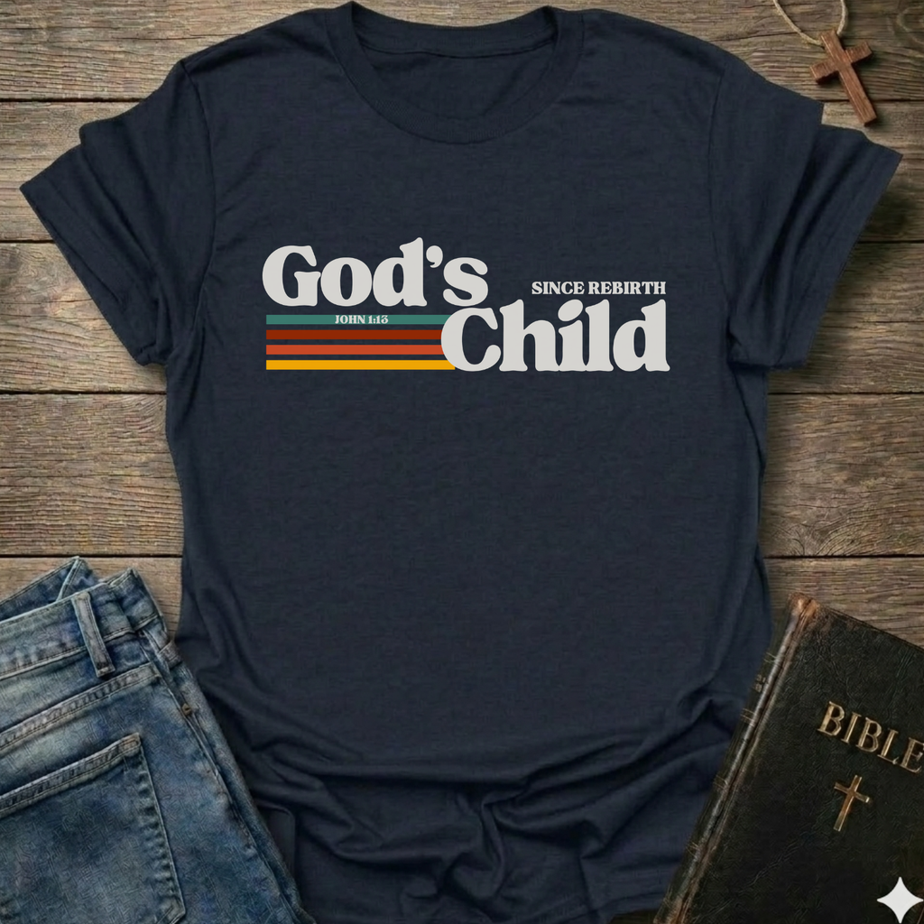Navy blue t-shirt with God's Child Since Rebirth Christian T-Shirt John 1:12 retro faith apparel conversation starter text on a wooden surface with jeans and a Bible.