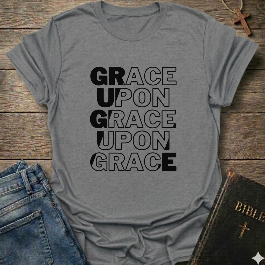 Gray t-shirt with 'GRACE UPON GRACE' text on a wooden surface with jeans and a Bible. Grace Upon Grace Christian T-Shirt John 1:16 bold faith apparel 