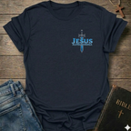 Navy Blue t-shirt with 'Jesus Alpha & Omega' and a Sword Christian T-Shirt Revelation 22:13 bold faith apparel Faith Forward design on a wooden surface with jeans and a Bible.