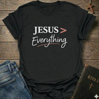 Black T-Shirt faith apparel conversation starter with 'JESUS > Everything' text on a wooden surface with jeans and a Bible.