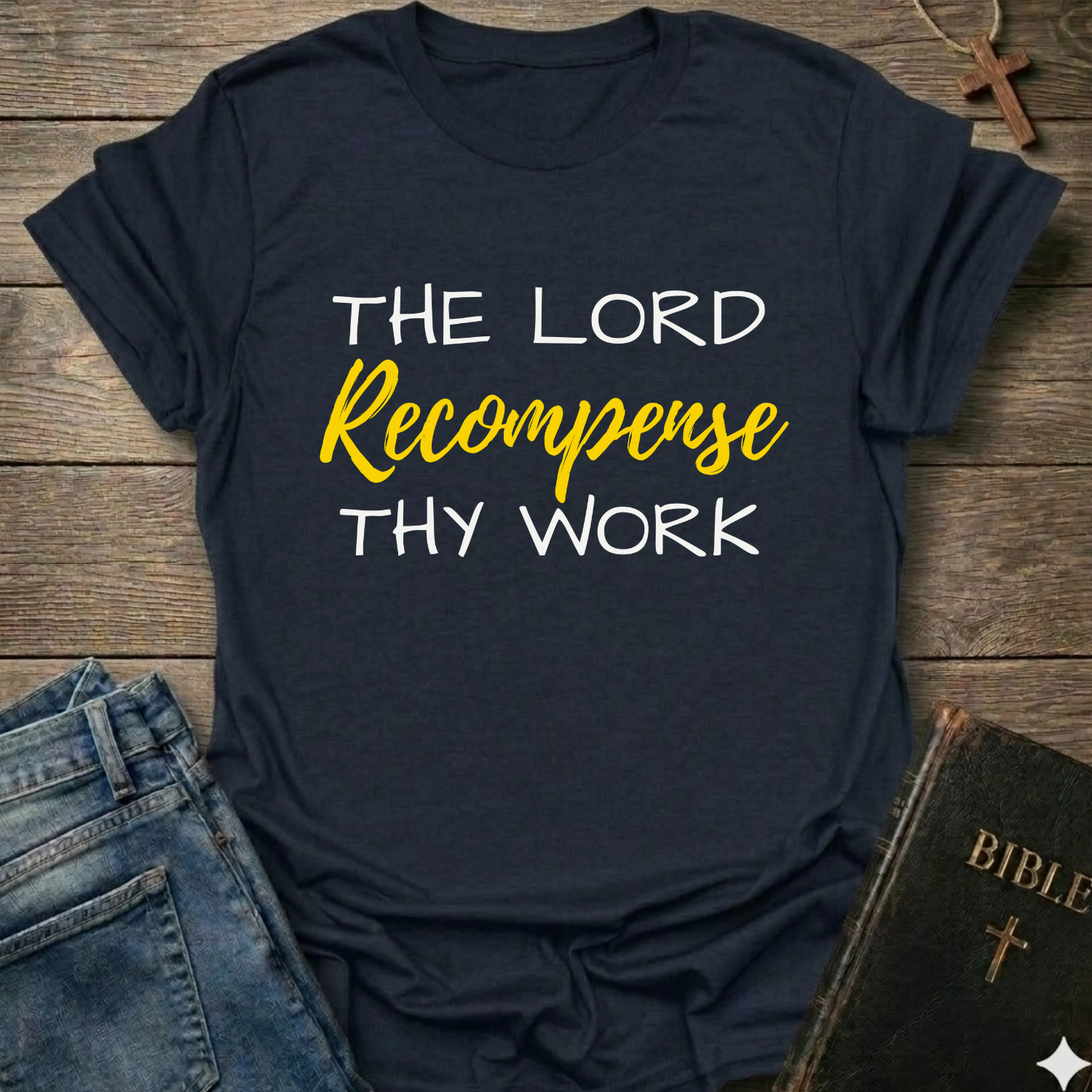 Black t-shirt with "The Lord Recompense Thy Work" Ruth 2:12 black gold text faith apparel Faith Forward on a wooden surface with jeans and a Bible.