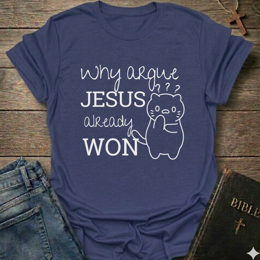 A purple graphic t-shirt laid flat on a rustic wooden surface, styled with a pair of blue jeans on the left and a black Bible on the bottom right. The t-shirt features a white graphic print that reads 'why argue JESUS already WON' alongside a simple line drawing of a cat with a raised paw and question marks above its head.